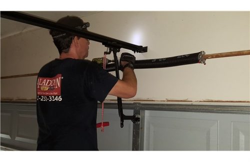 man fixing garage door spring