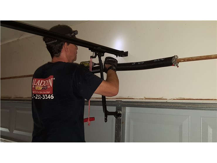 man fixing garage door spring