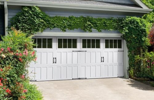 White double garage doors surrounded by ivy