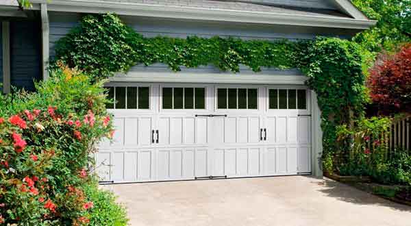 White double garage doors surrounded by ivy