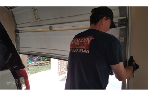 man putting garage door back on track