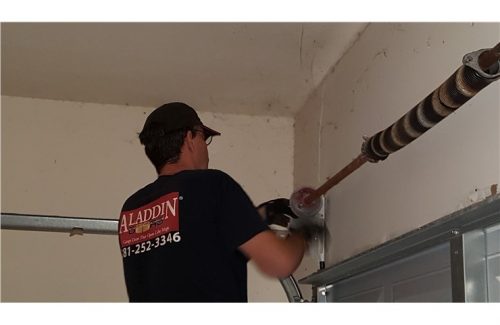 man fixing garage door spring