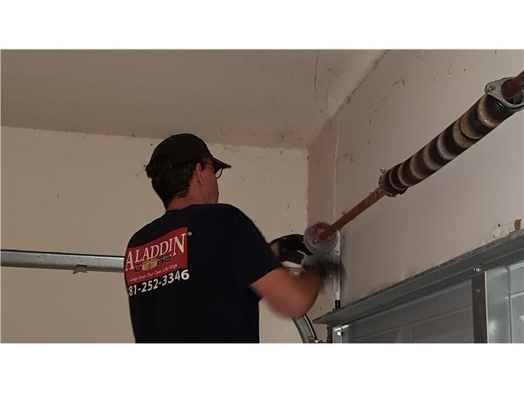 man fixing garage door spring