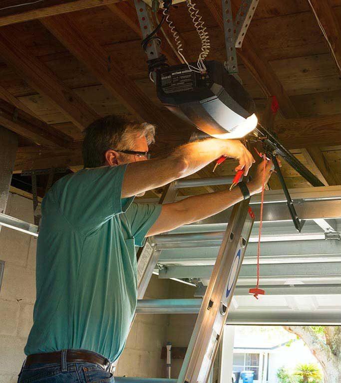 Specialist performing garage door opener repairs