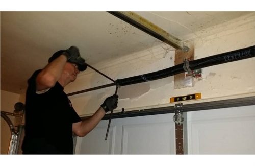 man fixing garage door spring