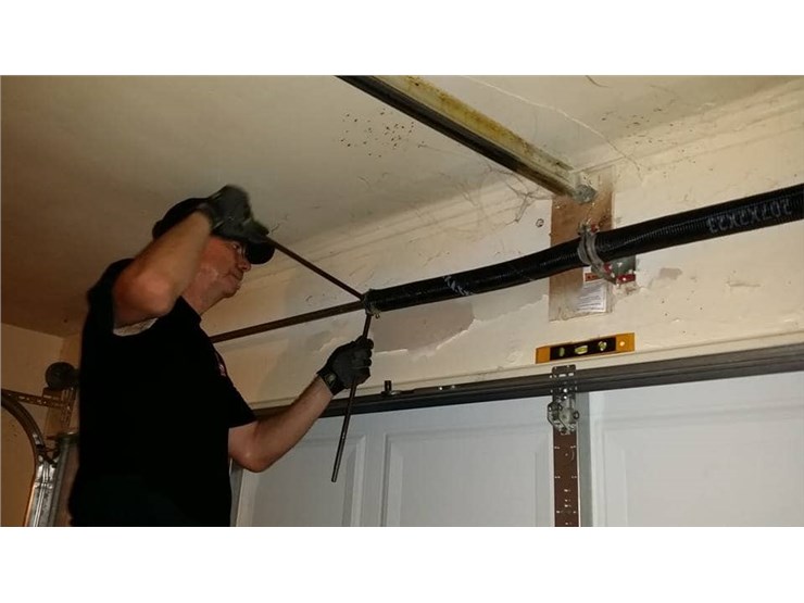 man fixing garage door spring