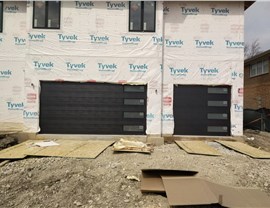 black garage doors on house under construction