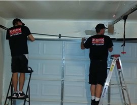 two aladdin employees installing garage door